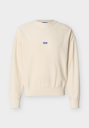 Cremefarbener Pullover mit langen Ärmeln, gerippten Bündchen und Saum, rundem Ausschnitt und kleinem blauen "HUGO"-Logo-Patch in der Mitte der Brust.