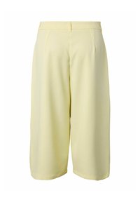 Shorts larges jaune clair jusqu'au genou avec passants de ceinture et plis subtils, vus de dos sur fond blanc.