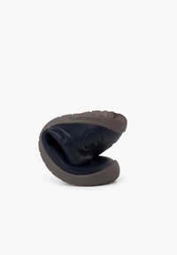 Scarpa flessibile blu navy con punta arrotondata, suola texturizzata grigio scuro e dettagli del logo. Il materiale sembra morbido e imbottito.