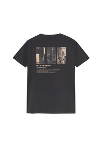 Zwarte katoenen T-shirt met een grafisch ontwerp op de achterkant, met beige tekst en foto-elementen gerangschikt in een rechthoekige lay-out.