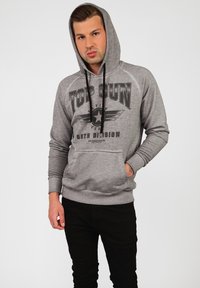 Grå hoodies med framficka, med svart text "TOP GUN" och stjärn grafik. Svarta snoddar och ribbade muddar.