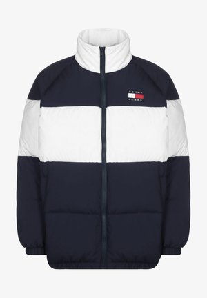 Navy un balta pūkā ar augstu apkakli, horizontāliem krāsu blokiem, ar rāvējslēdzēja aizdari un izšūtu logotipu uz krūšu zonas.