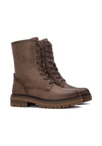 Botas de piel marrón hasta el tobillo con punta redonda, cordones delanteros y suela de goma texturizada. Ojetes de metal y un sutil detalle de logo en el lateral.