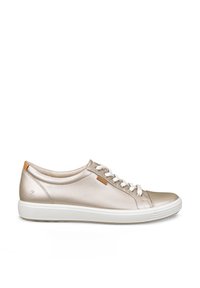 Baskets décontractées en cuir beige avec lacets blancs, semelle blanche et petite étiquette logo marron sur le côté, vues de l'extérieur.