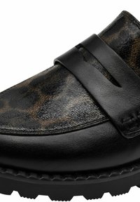Black leather slip-on shoe with a leopard print texture on the upper, featuring a wide strap and rugged sole with prominent treads.