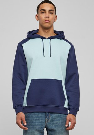 Kapuzensweatshirt mit einer hellblauen Vorderseite und dunkelblauen Ärmeln. Wird mit einer Kängurutasche, einer Kordelzugkapuze und gerippten Bündchen geliefert.