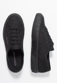 Czarne tekstylne sneakersy z teksturowaną gumową podeszwą, okrągłym noskiem, pięcioma oczkami i dyskretnym detalem logo z boku.