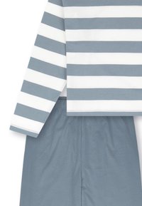 Baumwolloutfit mit grauen und weißen horizontalen Streifen oben und einfarbigen grauen Shorts. Weicher Stoff, lockere Passform und lange Ärmel.