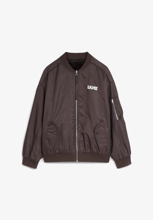 Bruine bomberjack met een ritssluiting aan de voorkant, geribbelde kraag, twee zijzakken en een klein "GAME" logo in het wit. Inclusief een ritssluiting zak op de arm.