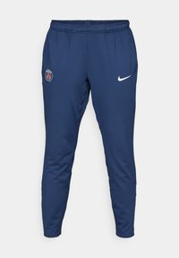 Marina träningsbyxor med elastisk midja, med en vit Nike-swoosh och en blå Paris Saint-Germain-logotyp på vänstra låret.