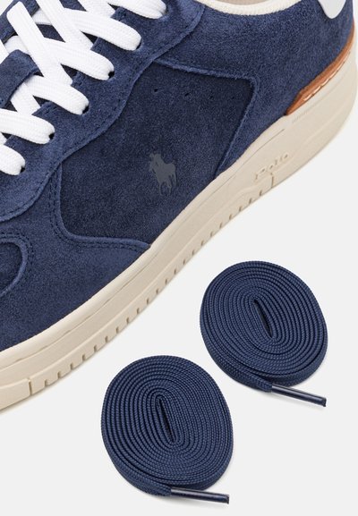 Σαβανί sneaker από σουέτ με άσπρα κορδόνια, καφέ δερμάτινα αξεσουάρ και λάστιχο σόλα. Περιλαμβάνει δύο επιπλέον σαβανί κορδόνια.