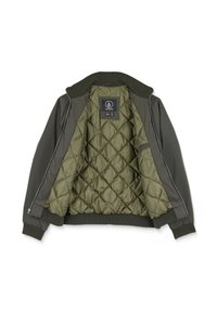 Veste zippée vert foncé avec col et poignets côtelés, montrant une doublure intérieure matelassée vert olive et une étiquette noire de la marque Volcom à l'intérieur.