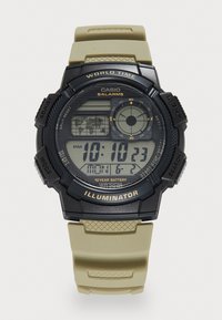 Montre numérique avec un boîtier noir et un bracelet en silicone beige. Les caractéristiques incluent un écran LCD, l'heure, la date et des fonctions d'alarme, ainsi que des boutons texturés.