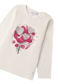 Langärmliges cremefarbenes Baumwoll-T-Shirt mit Grafik von rosa und roten herzförmigen Ballons, die Punktmuster und dezente Wolkenakzente aufweisen.