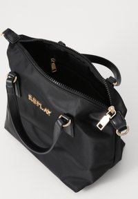 Borsa a mano in nylon nero con logo dorato, chiusura con zip, doppi manici e tasche interne. Caratterizzata da una superficie liscia e una forma strutturata.