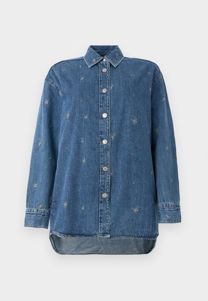 Niebieska koszula denimowa z zapięciem na guziki, długimi rękawami i zaokrąglonym dołem. Zawiera haftowane motywy w kontrastowych nitkach.
