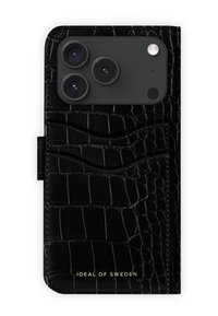 Svart skinntelefonveske med krokodillemønster, med utskjæringer for kameralinser og to kortlommer. Gullfarget merkevarelogo nederst.