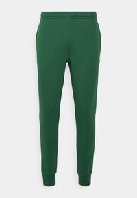 Gröna sweatpants med ribbad midja, avsmalnande ben och sidofickor. Tillverkad av mjukt, hållbart tyg. Har en liten logotyp på höften.