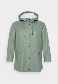 Veste imperméable vert clair avec capuche, boutons-pression sur le devant, cordons de serrage et deux poches à rabat, affichée sur fond blanc.