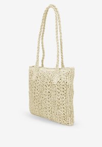 Bolso de tote de paja trenzada en color crema, con dos asas trenzadas y una superficie texturada con patrones similares a flores. Forma compacta y rectangular.