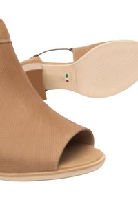 Tacchi aperti marroni con una parte superiore testurizzata, suola chiara e cinturino alla caviglia regolabile. L'interno mostra il nome del marchio e la misura.