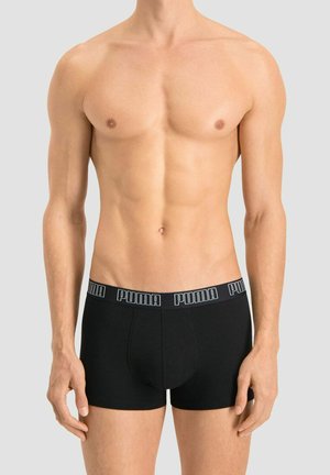 Black cotton boxer shorts with a wide elastic waistband featuring the "PUMA" logo in white. The design is form-fitting and seamless.
