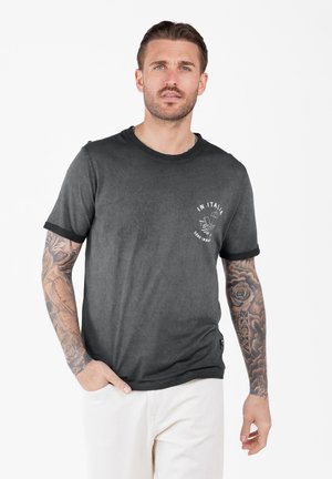 Herren T-Shirt mit kurzen Ärmeln in verblasstem Schwarz, mit rundem Ausschnitt und kontrastierenden schwarzen Ärmelabschlüssen. Enthält weißen Grafiktext auf der Brust.