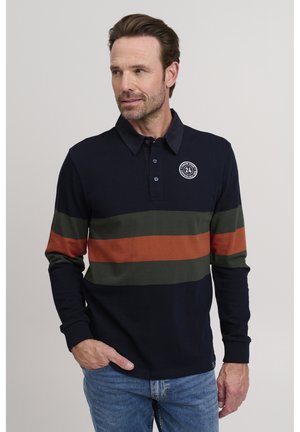 Dlhý polo tričko v námornícky modrej farbe s horizontálnymi pruhmi v zelenej a hrdzavej farbe, so zapínacím golierom a logom na ľavej hrudi.