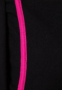 Tessuto nero con una consistenza morbida, caratterizzato da una cucitura rosa prominente lungo un lato. Il design è semplice e lineare.