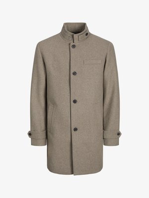 Ruskea villa takki, jossa on korkea kaulus, napitus, kaksi sivutaskua ja rintatasku. Varustettu mustilla nippeleillä ja käärittyjä hihoja.