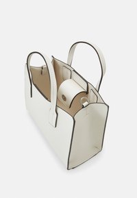 Sac à main rectangulaire blanc avec deux anses, dessus ouvert, intérieur beige, et une petite poche à rabat avec fermeture à bouton à l'intérieur.