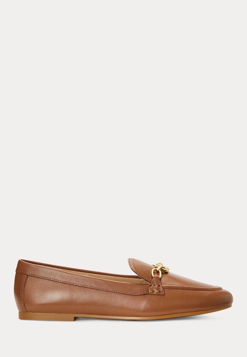 Mocassin marron en cuir pour femme, style slip-on, avec détail en métal doré et semelle plate, présenté de profil sur fond blanc.