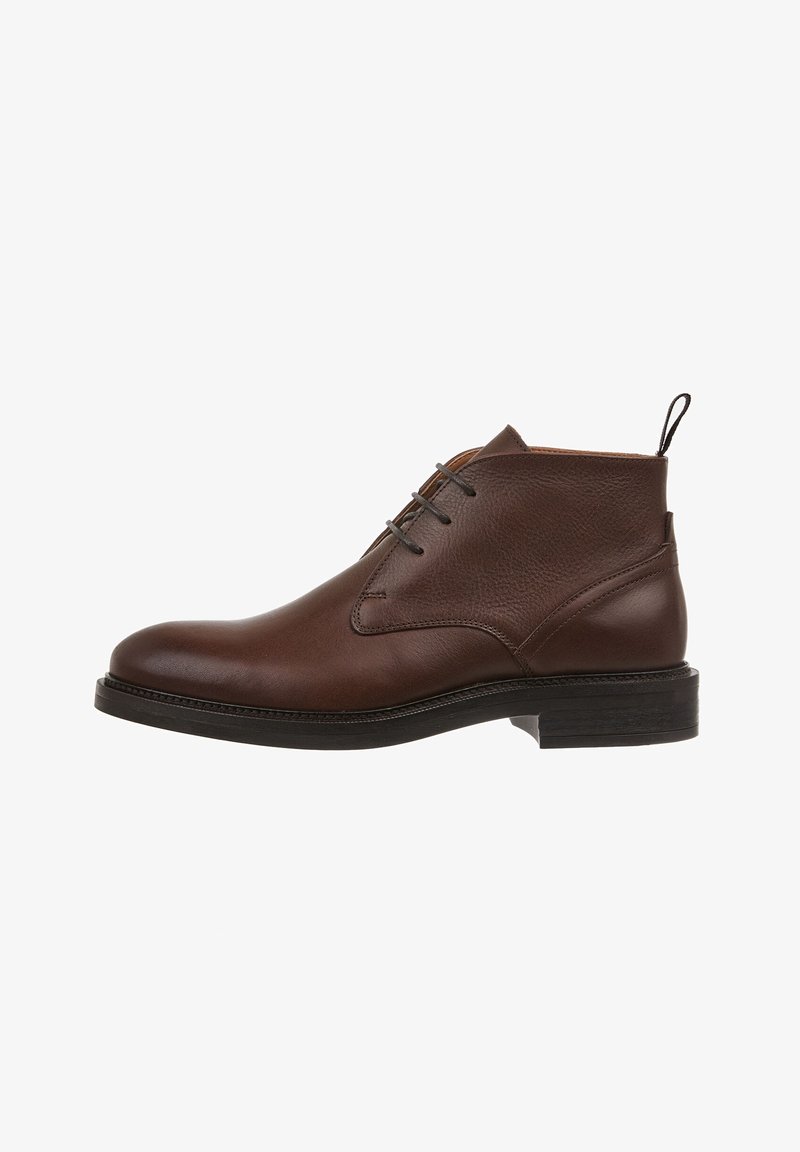 Bottine marron en cuir avec lacets noirs, bout arrondi, languette au talon et semelle noire avec petit talon empilé.