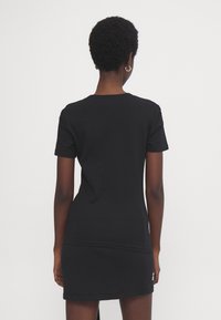 Svart kortermet t-skjortekjole laget av bomull, med rund halslinje, fitted fasong og en sømdetalj nær midjen.