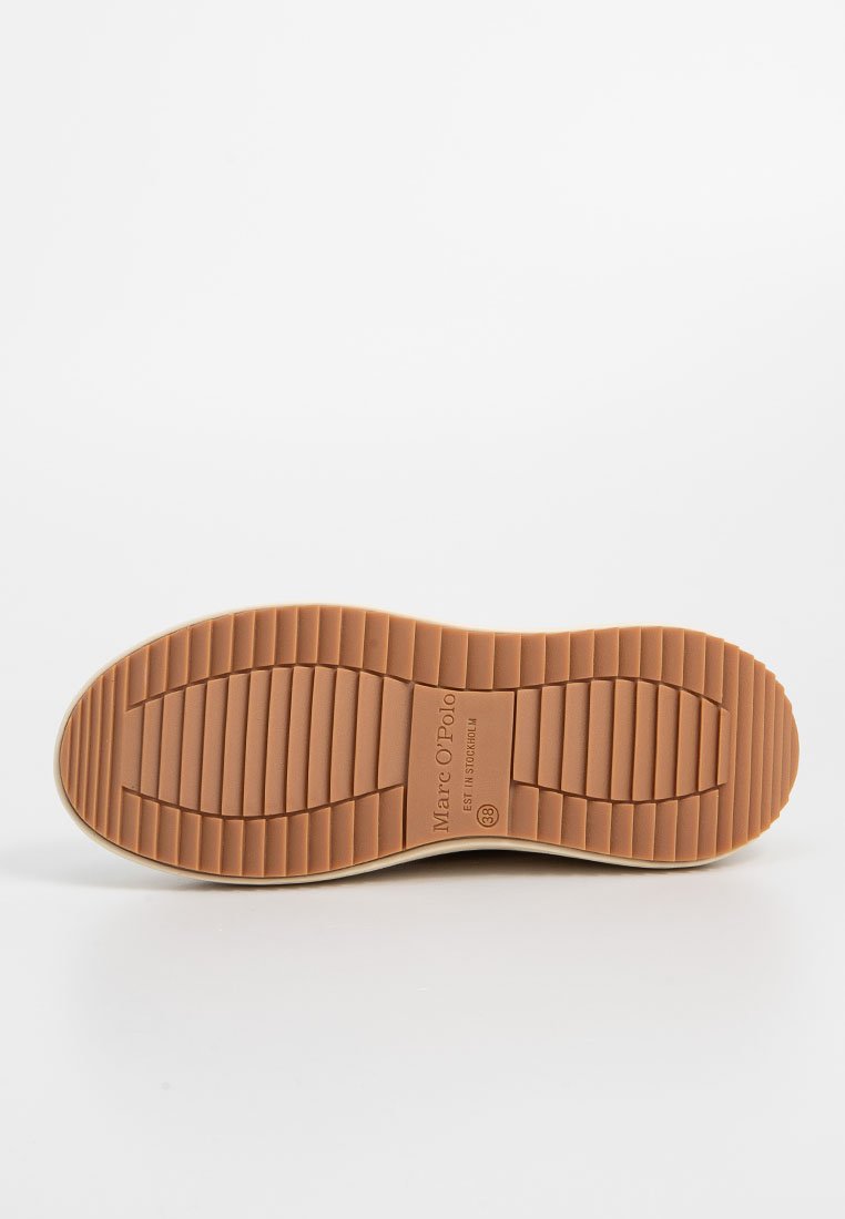 Die Sohle des Schuhs verfügt über ein braunes Gummidesign mit horizontalen Rillen, einer runden Zehenform und einer geprägten Marke in der Mitte.