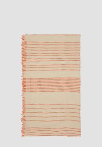 Couverture tissée beige avec des motifs rayés orange alternés et des bords en frange. Texture lisse avec des motifs en grille et des lignes. Style léger et décontracté.
