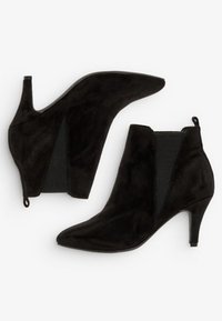 Schwarze Wildleder-Stiefeletten mit spitzem Zehenbereich, elastischen Seitenpaneelen und schlankem Absatz. Sauberes Design ohne sichtbare Muster.