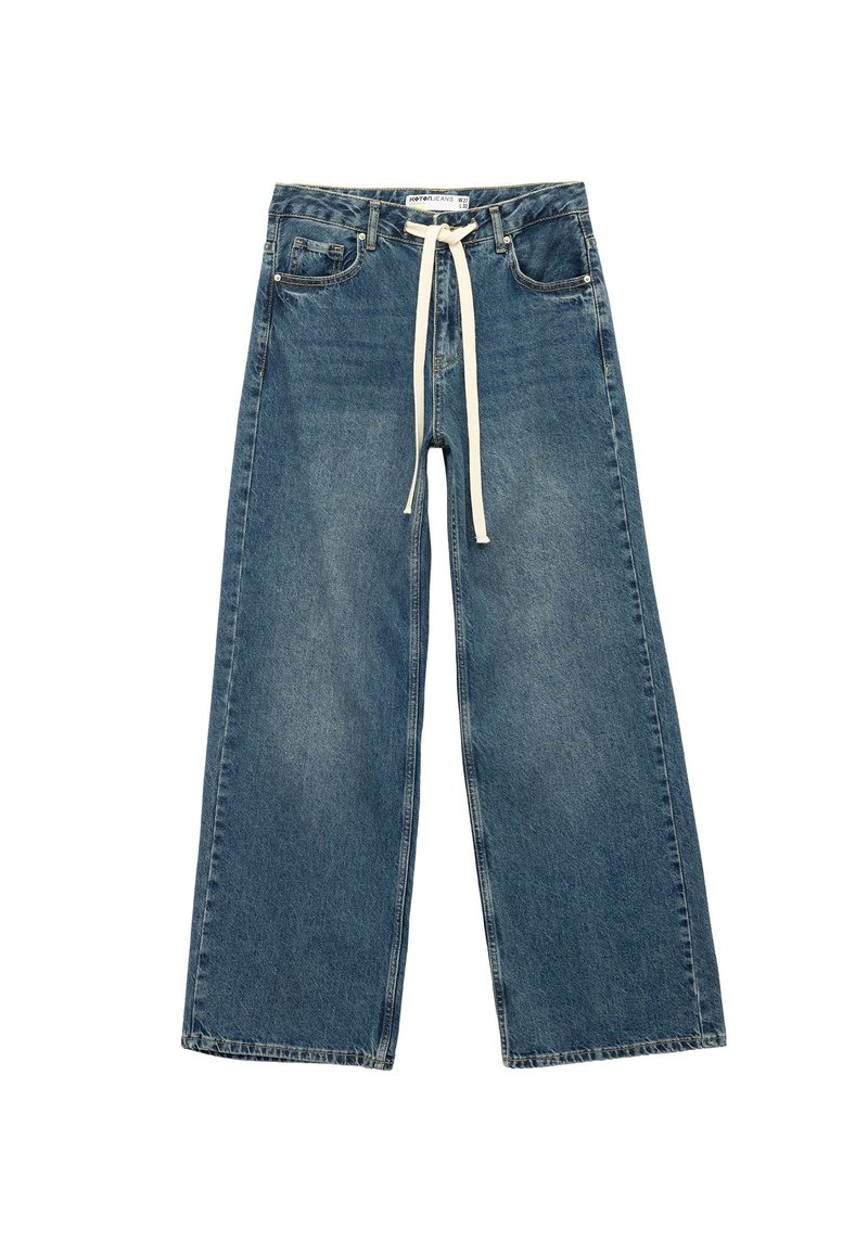 Pantalones de mezclilla anchos en azul con bolsillos frontales y un cordón blanco atado en la cintura, colocados en una superficie blanca.