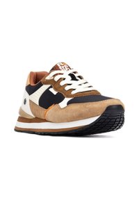Zapatilla con parte superior de ante marrón y negro, acentos blancos y tejido texturizado. Cuenta con un diseño de cordones y suela de goma con una banda de rodadura distintiva.