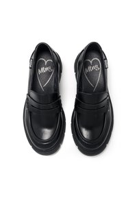Scarpe slip-on nere con tomaia in pelle liscia, dotate di due ampie fascette e suola in gomma. L'interno presenta un dettaglio con logo a forma di cuore.