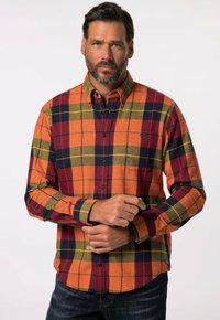 Fleece skjorte i orange, rød og marineblå tern med knap-krave, brystlomme og lange ærmer. Blød tekstur med synlig syning.