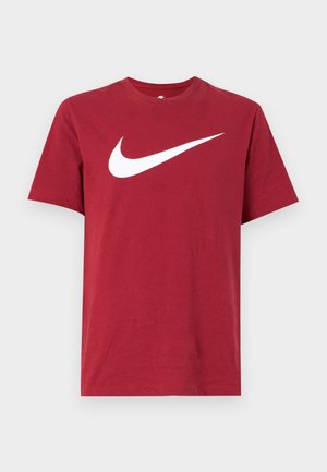 Camiseta de algodón roja con mangas cortas y cuello redondo. Presenta un gran logo Nike Swoosh blanco en el frente. Textura suave, diseño casual.