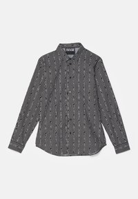 Maglietta a maniche lunghe a righe bianche e nere con collo, caratterizzata da linee verticali e motivi testuali. Chiusura con bottoni sul davanti e orlo curvo.