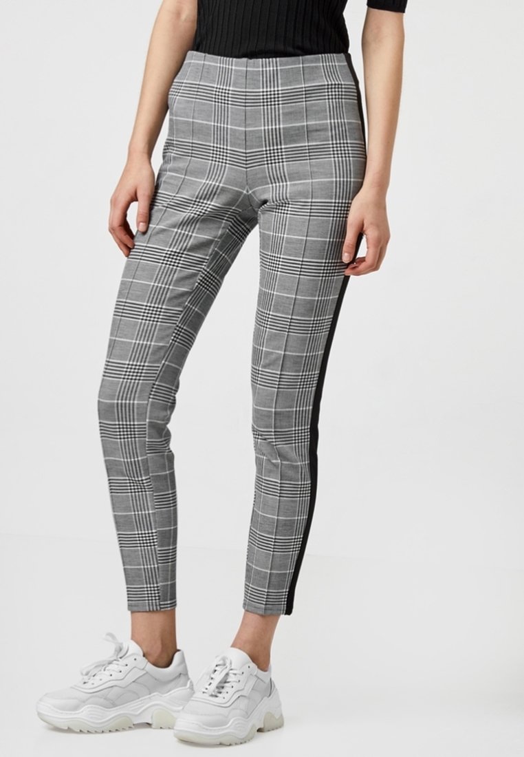 Gray plaid trousers with a fitted design, featuring black side stripes and a smooth texture. Worn with white chunky sneakers.