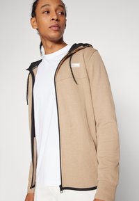 Jack & Jones JCOAIR HOOD - Majica s kapuljačom i patentnim zatvaračem - crockery detail:melange