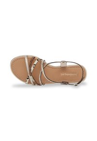 Leather sandal with metallic silver straps and a tan padded insole. Features a flat sole with brown accents and an ankle strap for support.