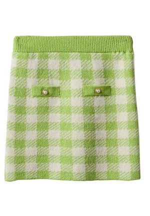 Jupe en maille à carreaux verts et blancs avec une ceinture côtelée et deux petites poches avant, chacune avec un bouton en perle.
