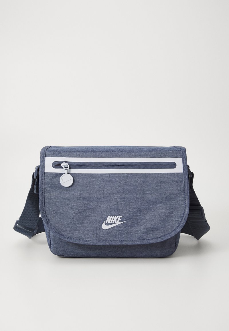 Borsa a tracolla blu navy realizzata in tessuto testurizzato, presenta una tasca frontale con zip, una tracolla regolabile e il logo Nike bianco sul davanti.