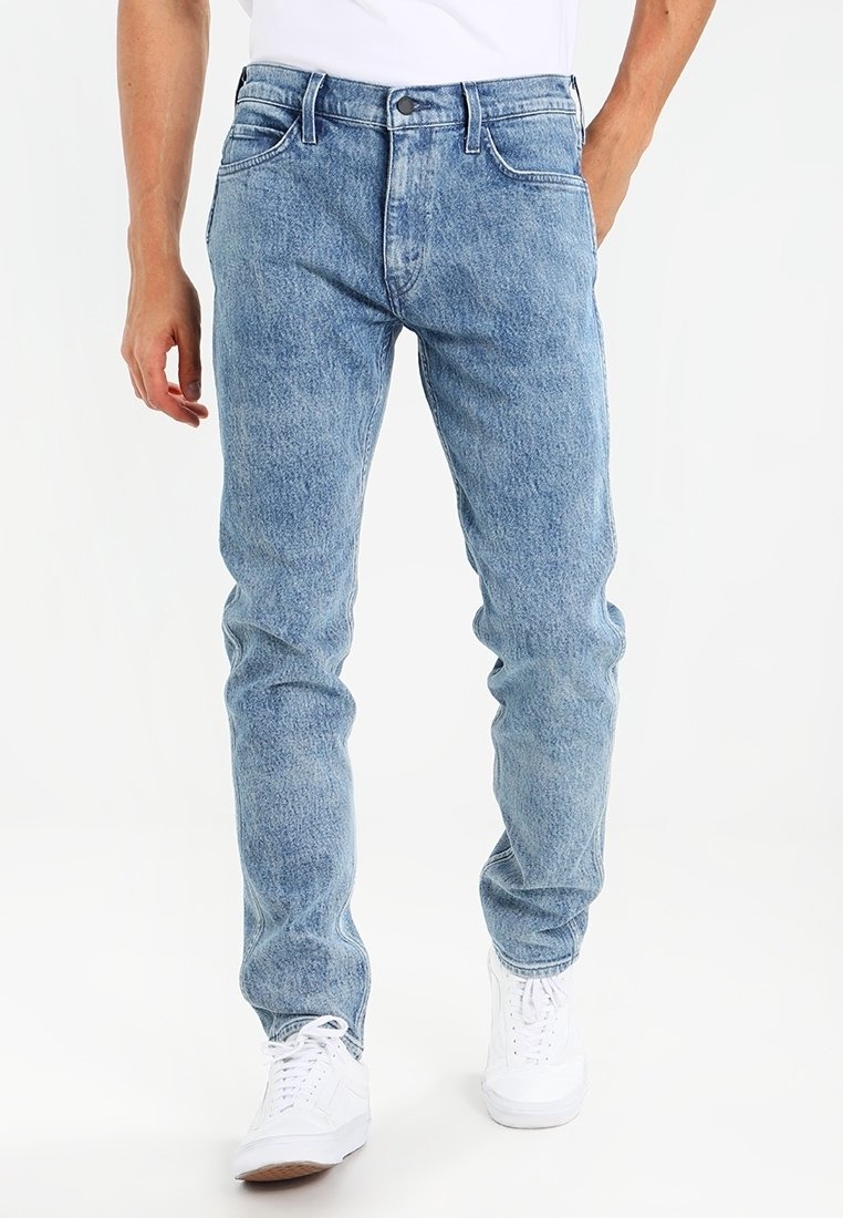 Ljusblå denimjeans med rak passform, som har fem fickor, en knappgylf av metall och subtila blekningar över hela tyget.
