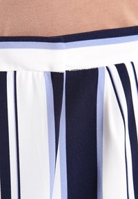 Mnohobarevné šaty s vodorovnými pruhy v námořnické modré, světle modré a bílé barvě, s hladkým materiálem a elastickým pasem.